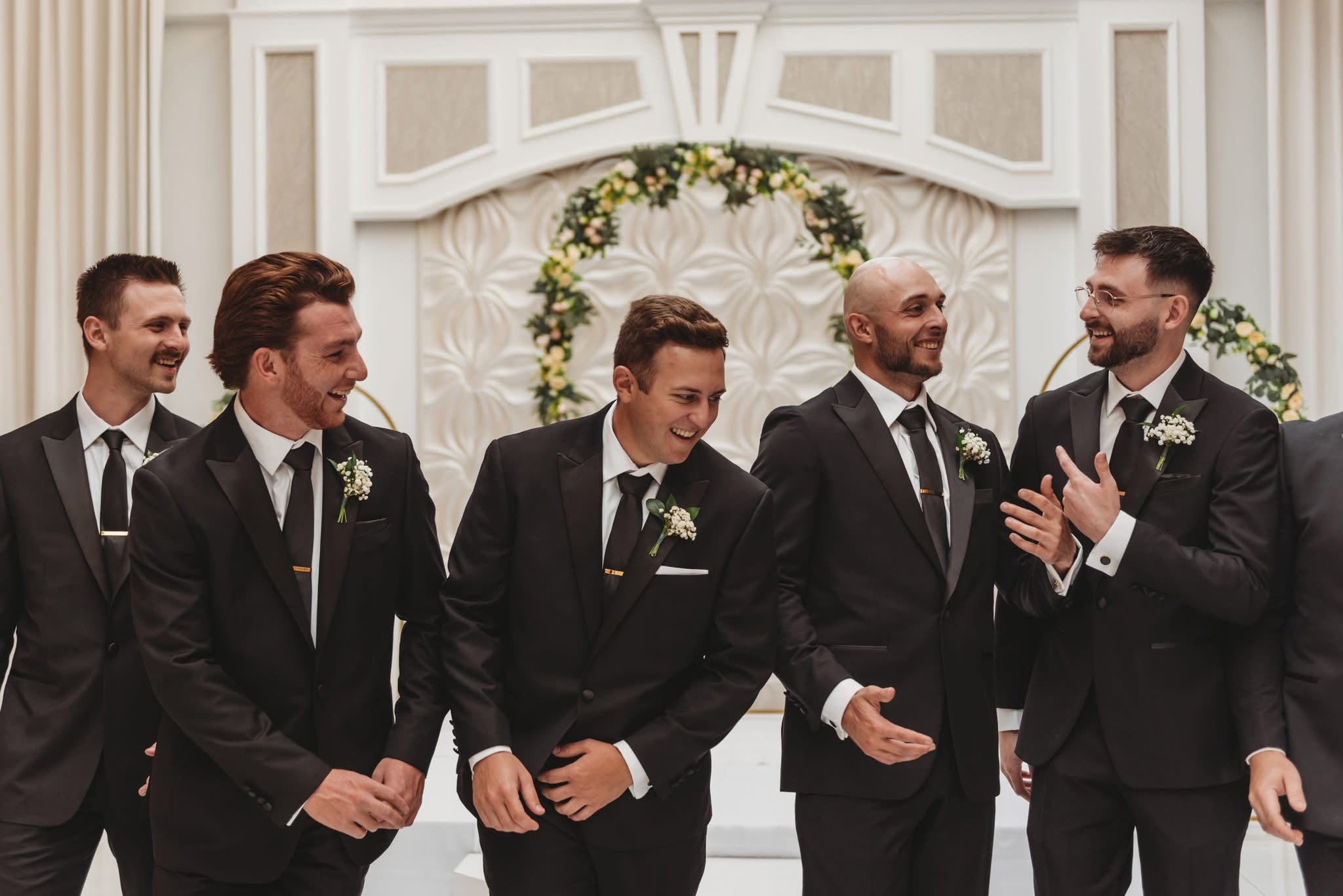 Groom and groomsmen wearing black peak lapel tuxedos.