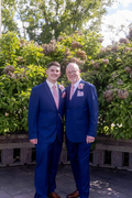 Well dressed groom and father both wearing cobalt blue suits, and white dress shirts.