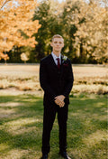 Handsome groom wearing a solid black 3 piece suit.