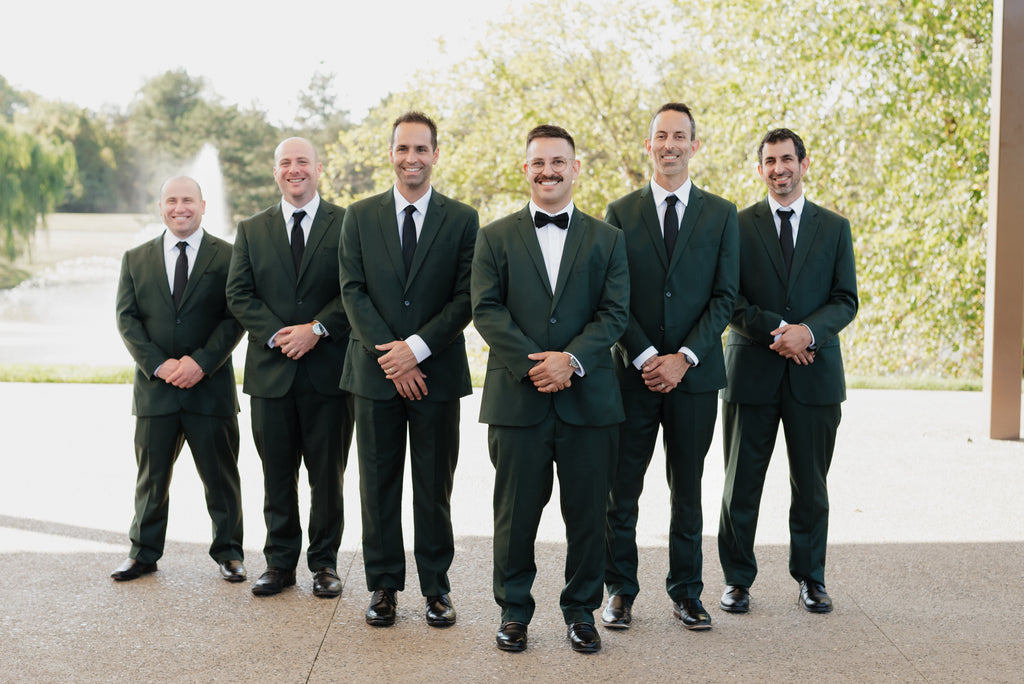Groom and groomsmen wearing hunter green suits.