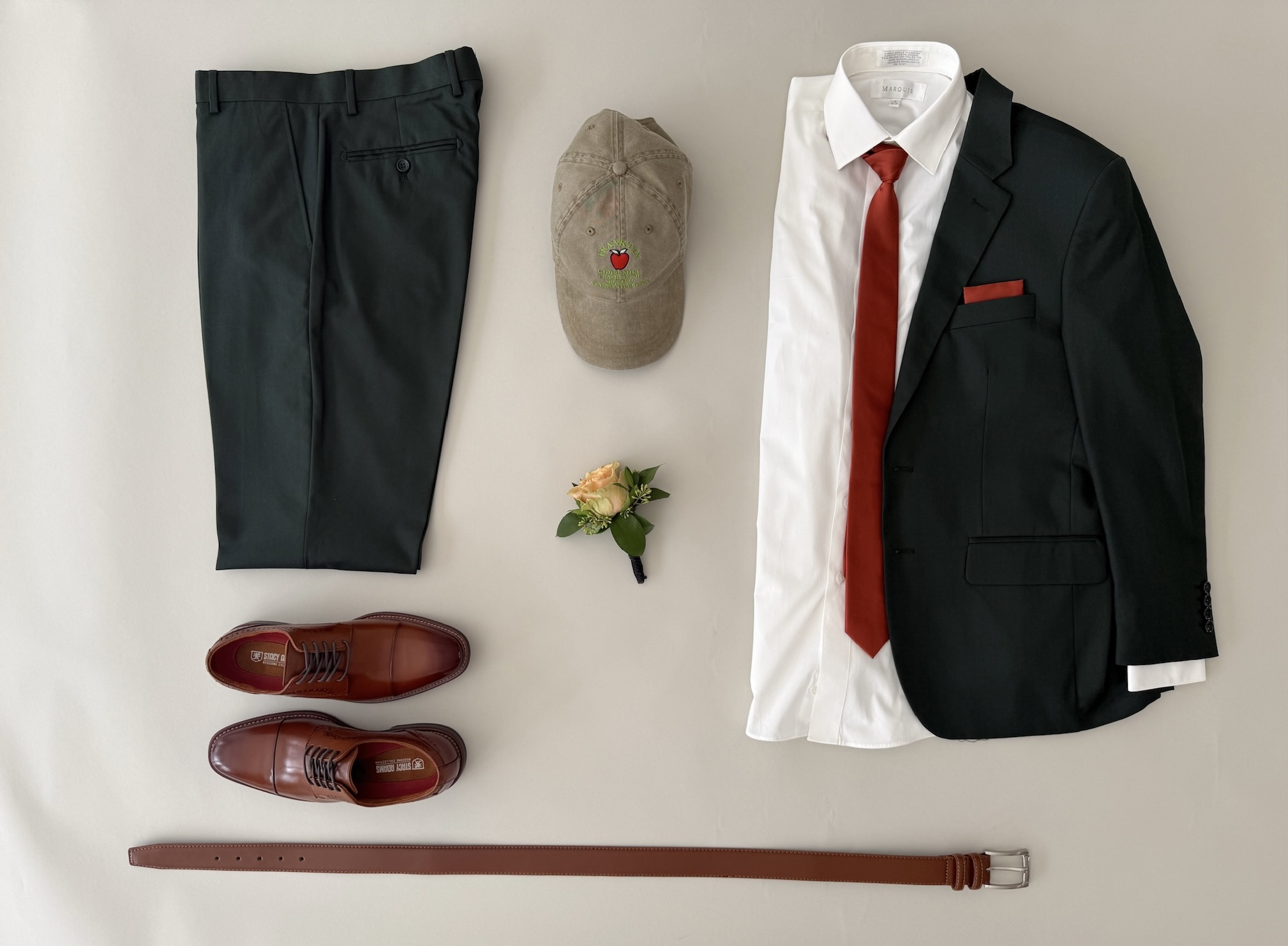 Studio image hunter green suit, ivory dress shirt, tie and matching pocket square, cognac shoes and cognac belt.