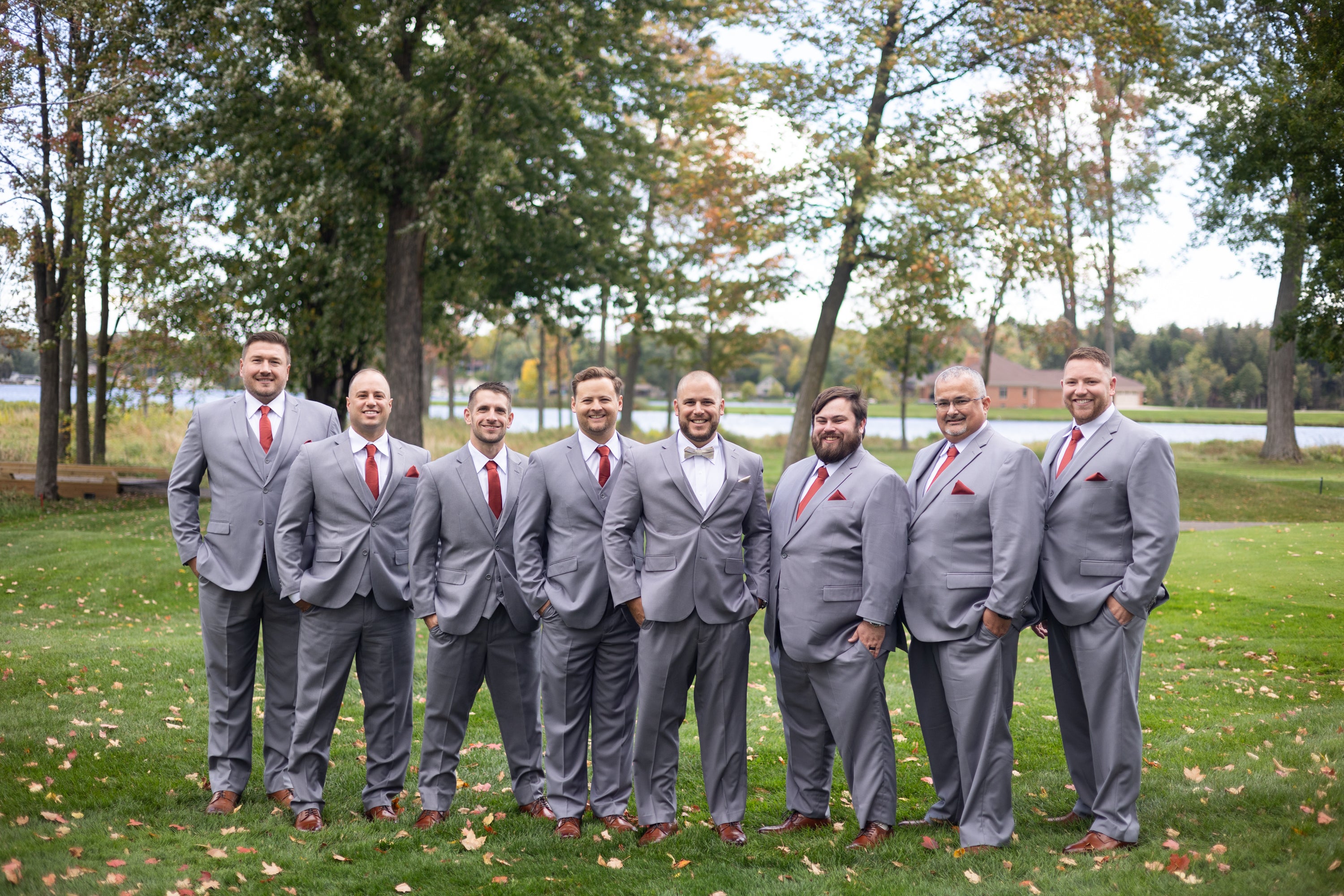 Groom and 7 groomsment wearing light grey suits.