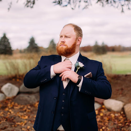 Groom wearing a handsome navy vested suit.