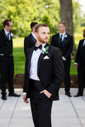 Groom in a timeless black notch lapel tuxedo, black bowtie and cummerbund, laydown formal shirt.