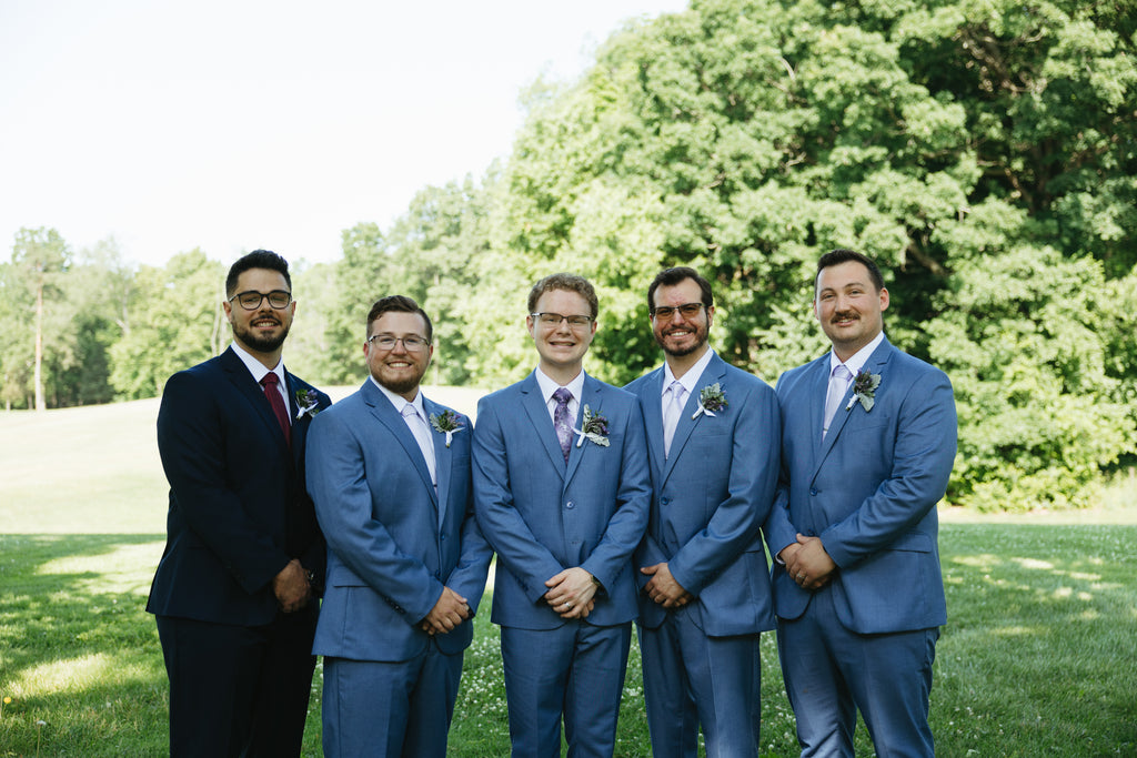 Groom and groomsmen, 4 wearing powder blue suits, one wearing a black suit.